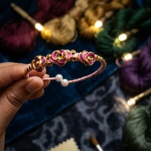 Hand is holding up a single, intricate thread bangle
